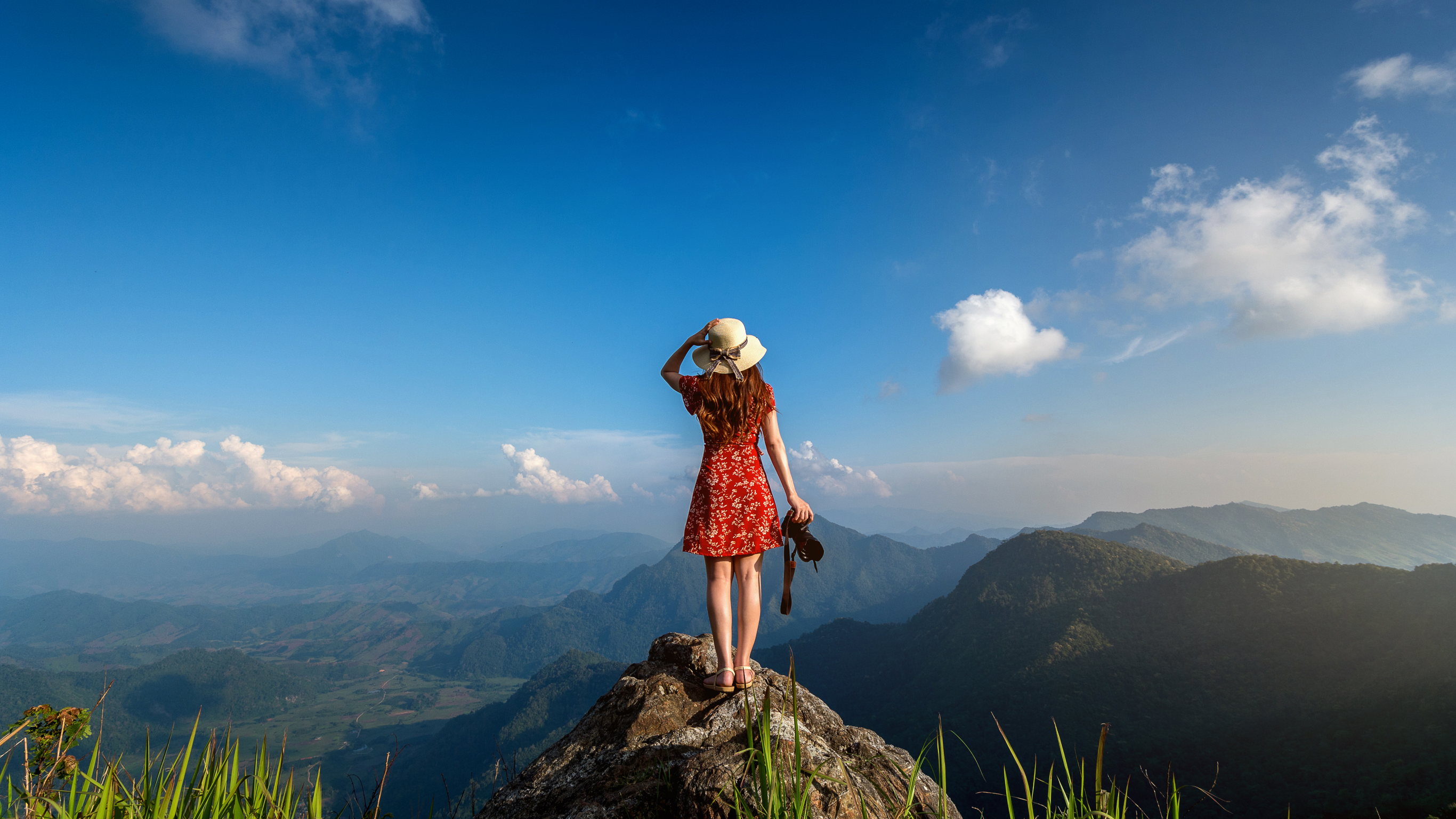 Woman standing on a mountain top overlooking a scenic view