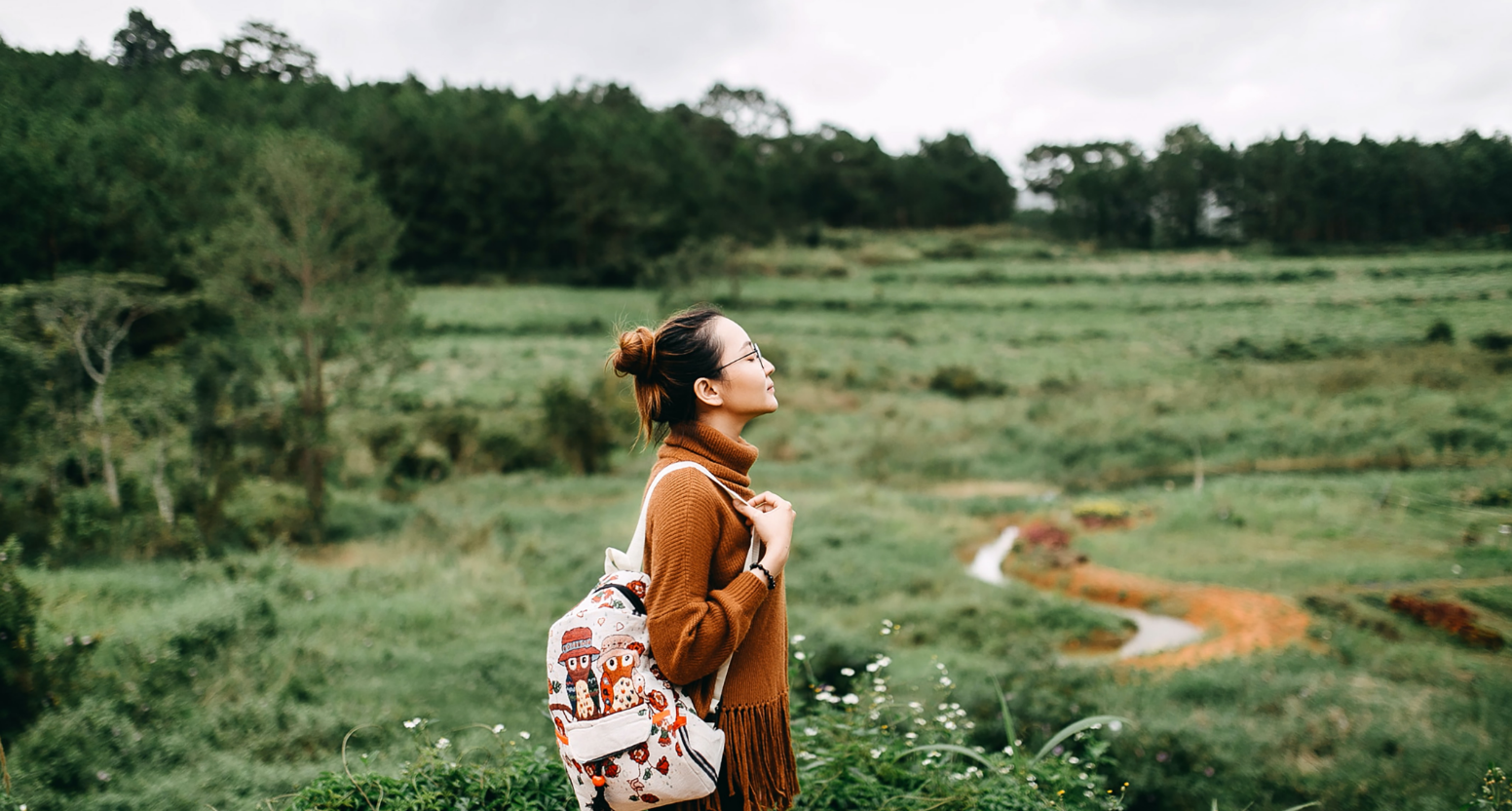 Person with backpack walking through a field