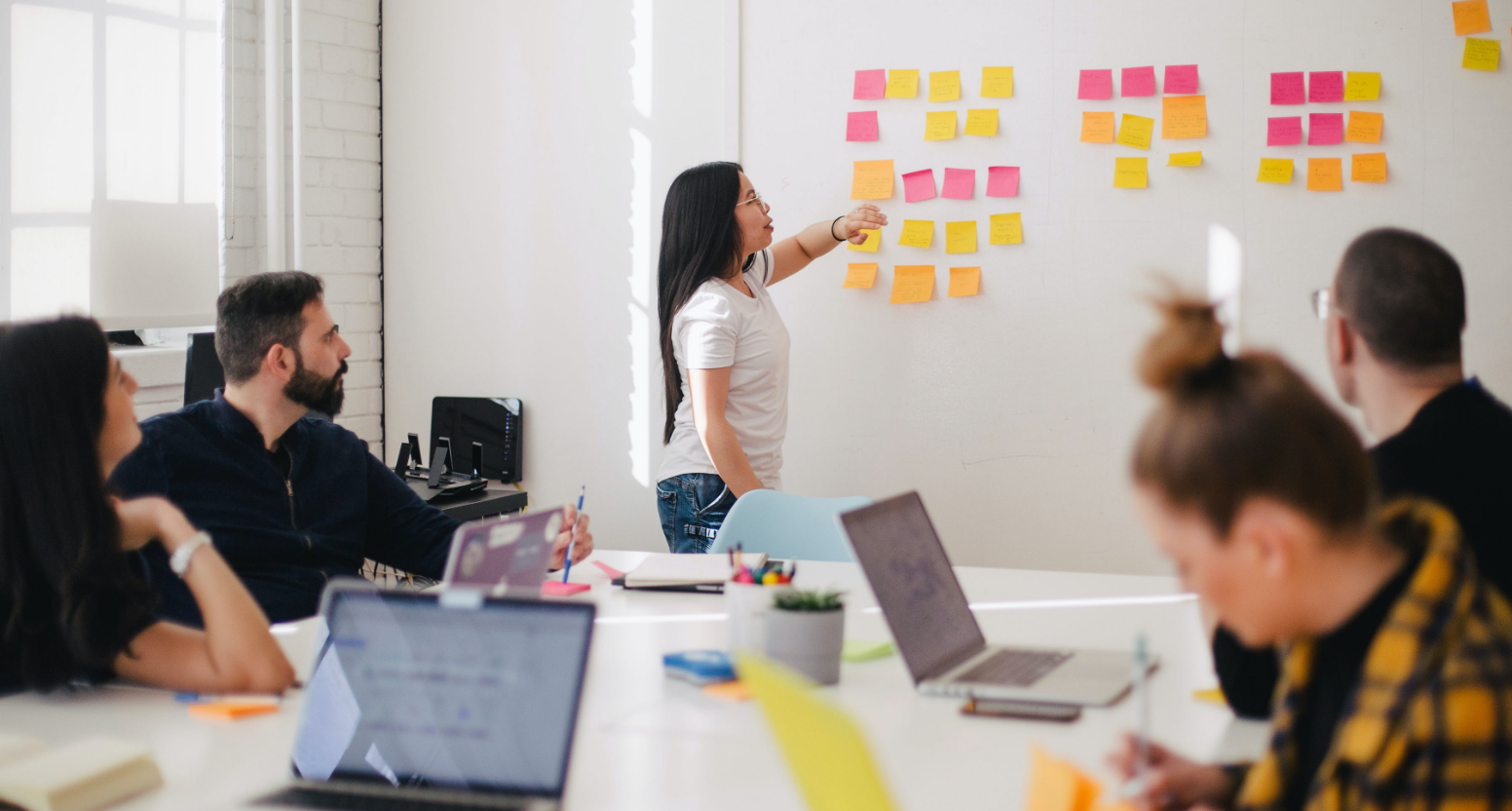 Group of people having a meeting with sticky notes on the wall